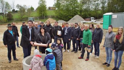 Bild: mmj
Pfarrer Wolfgang Dietz und Bürgermeisterin Birgit Höcherl mit der "Zeitkapsel", die im Fundament des neuen Kindergartens einen Platz für immer bekommt. Am Bau beteiligte Personen und Firmen verfolgten die Grundsteinlegung.
