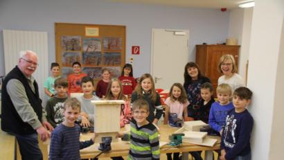 Bild: frd
Der Vorsitzende des OWV Oberviechtach, Günther Flierl (links) baute mit den Niedermuracher Grundschülern nach dem Muster im Vordergrund Fledermaus-Häuschen und erzählte ihnen einiges über diese Tierart.