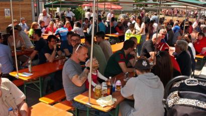 Bild: zer
Dicht gedrängt sitzen die Besucher unter den schattenspendenden Zeltplanen auf dem Dorfplatz.