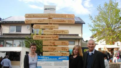 Bild: gis
Sprecherin Manuela Hornung und Christina Braun von der Ortsentwicklungsgruppe sowie zweiter Bürgermeister Karl Heinz Glaser (von links) präsentieren beim Dorffest den neuen Schilderbaum und die Infotafel zum 50. Breitengrad.