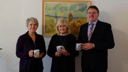 Bild: Stefanie Gradl
Adolfine Nitschke (links) und Bürgermeister Hans-Martin Schertl nehmen die neuen Tassen entgegen, die Künstlerin Christina Hausmann (Mitte) gestaltet hat.