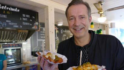 Bild: Gert-Dieter Meier
Sterne-Koch Alexander Herrmann steht mit Pommesschalen im einem Freibadkiosk. Foto: Gert-Dieter Meier/AHa-Effekt