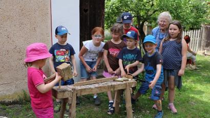 Bild: gru
Die Kinder beim Einschlagen der spitzen Zähnen für einen Rechen im Hintergrund Margarete Jäckel die Besitzerin des Goglhof