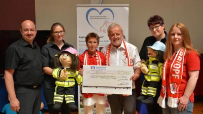 Bild: eya
Bernd Hofmann, Vorsitzender des FC-Bayern-Fanclubs (Fünfter von links), überreichte den Scheck an das Rescue Team mit Geschäftsleiter Marco Frischholz (links).