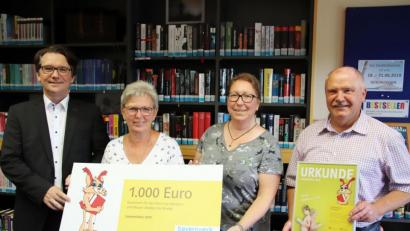 Bild: jma
Aus den Händen von Markus Windisch nehmen Renate Schneider und Leiterin Petra Danzer das mit 1000 Euro verbundene "Lesezeichen" für die Stadtbibliothek entgegen. Auch Bürgermeister Peter Lehr freut sich über die Auszeichnung.
