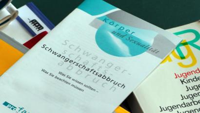 Bild: Jens Büttner/dpa
Symbolbild: Bücher und Informationshefte liegen auf einem Tisch.