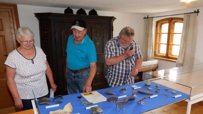 Bild: Gerhard Götz
Maritta Lorenz, Laurenz Lorenz und Heinrich Schwarz (von links) betrachten und erklären die archäologischen Fundstücke. Vorne links eine Ofenkachel vom Aiherlhof aus dem 15. Jahrhundert.