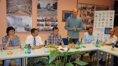 Bild: Bühner
Juri Sargelis vom Bundesverband russischsprachiger Eltern (stehend) stellt seinen Verband vor. Bürgermeister Jens Meyer (Zweiter von links) beantwortet kommunalpolitische Fragen. Moderator ist 
Waldemar Hock vom Verein Neue Zeiten (Dritter von links)