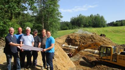 Bild: fz
Bürgermeister Anton Kappl (rechts) informiert sich beim Durchlass der Luhe bei Ingenieur und Bauleiter Dietmar Hammerl (links) und Vertretern der bauausführenden Firmen über den Verlauf der Baumaßnahme. Im Hintergrund ist die alte Straße zu sehen.