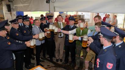 Bild: tkr
Nachdem der Ehrenschirmherr Landrat Thomas Ebeling (Mitte) angezapft hatte, schenkte er auch gleich ein paar Gläser ein. Zusammen mit den Vorständen des Jubelvereins und der Patenvereine, Braumeister Franz Vogl und Sohn, sowie Schirmherrn Bürgermeister Norbert Eckl (linke Bildhälfte, ohne Uniform) stieß er dann auf gutes Gelingen des Festes an.