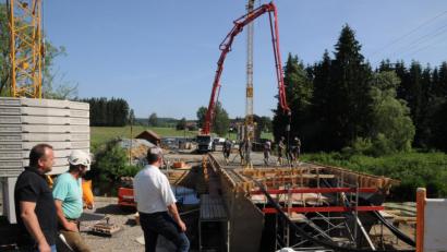 Bild: bey
Bauamtsleiter Uli Rupprecht (links) und Bürgermeister Rainer Rewitzer (rechts) lassen sich von Polier Alexander Weihrauch (Mitte) über den Stand des Betonierens der Pfreimdbrücke informieren.