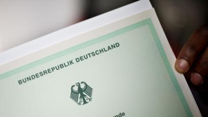 Symbolbild: Julian Stratenschulte/dpa
Eine Einbürgerungsurkunde der Bundesrepublik Deutschland.