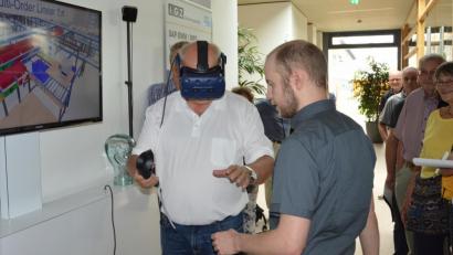 Bild: weu
Akademievorsitzender Josef Schönhammer testet ein virtuell begehbares Lager, in dem verschiedene Arbeitsplätze simuliert und optimiert werden können.