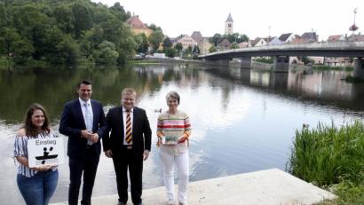 Bild: Hirsch
Die Vertreterinnen des Tourismuszentrums Nabburg, Alexandra Beier (rechts) und Julia Braun (links) stellten an der sanierten Anlegestelle in Burglengenfeld gemeinsam mit Landrat Thomas Ebeling (Zweiter von links) und Bürgermeister Thomas Gesche (Zweiter von rechts) die neue Bootswanderkarte vor.