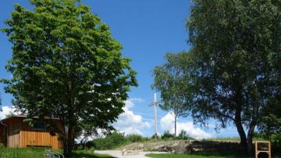 Bild: fjo
Direkt unterm neuen Holzkreuz (Mitte) erstreckt sich das Areal des neu geschaffenen Kräutergartens, dem vis-a-vis der Lernort Biene (links) gegenübersteht. Morgen Vormittag ist feierliche Einweihung für die gesamte Bevölkerung.