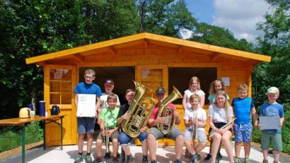 Bild: enz
Die Maiersreuther Kinder vor ihrem neuen Häuschen am Muglbach.