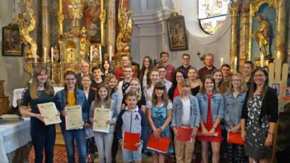Bild: rkp
Seit 15 Jahren bereichert der Kinder- und Jugendchor "Mosaik" um Leiterin Paula Deml (rechts) die Kirchenmusik in der Pfarrgemeinde Thanstein. Treue Sänger wurden geehrt.