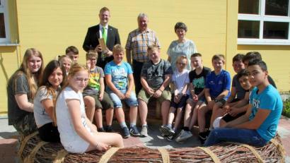 Bild: sön
Schüler erproben die neue Weidensitzbank im Schulhof der Mittelschule. Im Hintergrund (von links) Michael Zinner, Marketing-Leiter der VR-Bank Niederbayern-Oberpfalz, Bürgermeister Markus Dollacker und Rektorin Helga Gradl.