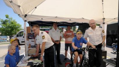 Bild: bey
Polizeihauptmeister Wolfgang Piehler (rechts) überwacht die simulierte Fahrradtour von Thomas Schödl. Im Hintergrund beobachtet Erster Polizeihauptkommissar Martin Zehent gemeinsam mit Bernhard Schödl die Fahrt des Buben. Polizeihauptkommissar Jakob Stahl (links) erklärt die Funktion von Brillen, die den Genuss von Rauschgift und Alkohol simulieren.