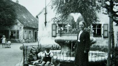 Bild: njn
Ein Bild aus der Nachkriegszeit: Der Springbrunnen in der Pfarrgasse mit Margarete Baierl (rechts), die zusammen mit ihrem Ehemann Hans den Brunnen viele Jahrzehnte betreute.
