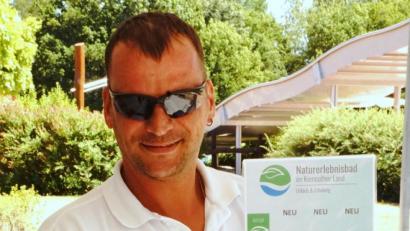Bild: bkr
Bademeister Kai Wolf bringt das Plakat mit den Feierabendtarifen am Eingang des Naturerlebnisbades an.