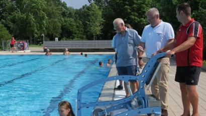 Bild: Hirsch
Michaela Krämer stellte sich für den Premiereneinsatz des Pool-Lifters im Erlebnisbad zur Verfügung. Bademeister Michael Maget, Oberbürgermeister Andreas Feller und Bäderleiter Rüdiger Frey (von rechts) hoben sie ins Wasser.