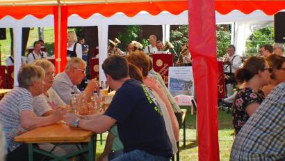 Bild: enz
Trotz hochsommerlicher Temperaturen fanden zahlreiche Gäste den Weg zum Gartenfest. Im Hintergrund die Blaskapelle Ernestgrün mit der Sängerin Kerstin Rustler