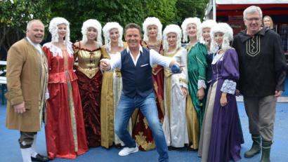 Bild: exb/Stella Welnhofer
Gruppenbild mit Stefan Mross nach der Generalprobe: Michael Welnhofer (links) mit den „Grün-Weiß“-Mädels im Barockkostüm und Goldwäscher Günter Zithier waren von der unkomplizierten Art des Moderators bei der Live-Sendung „Immer wieder sonntags“ begeistert.