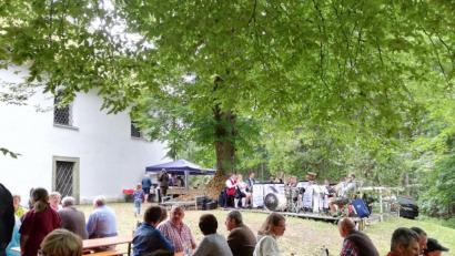 Bild: ens
Unter dem Blätterdach macht den Besuchern des Gartenfests am Ulrichsberg auch der gelegentliche Nieselregen nichts aus. Die "Eslarner Werkstatt-Musikanten" sorgen derweil für die richtige Atmosphäre.