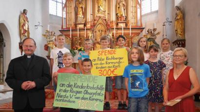 Bild: exb
In einer von Pfarrer Heribert Stretz (links) zelebrierten Kindermesse überreichen die Erstkommunikanten 1300 Euro an Waltraud Wagner (rechts) von der Kinderkrebshilfe in der Region Oberpfalz-Nord.