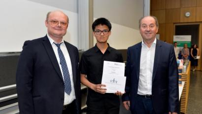 Bild: FAU/Harald Sippel
Laudator Dr. Ralph Puchta (links) von der Universität Erlangen-Nürnberg und Reinhard Schneider (rechts), Vorsitzender der Dr.-Hans-Riegel-Stiftung, gratulieren Chemie-Preisträger Daniel Zhou (Mitte).