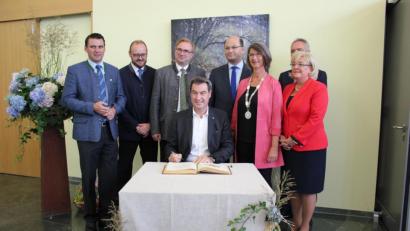 Bild: exb/Angelika Niedermeier
Ministerpräsident Markus Söder trägt sich in das Goldene Buch der Stadt Maxhütte-Haidhof ein.