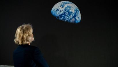 Bild: Daniel Karmann
Eine Frau betrachet das Bild "Earthrise".
