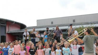 Bild: ads
Die Schnaittenbacher Schüler ließen sich von der Begeisterung der Band „Epicureans“ für Musik und Gesang mitreißen und hatten einen Heidenspaß bei ihrem Auftritt mit der Band vor großem Publikum beim Pausenhofkonzert.