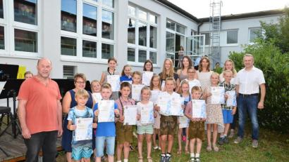 Bild: fjo
Musikalischer Leiter Hermann Mack (links) und zweiter Vorsitzender Josef Schmucker (rechts) verleihen an 26 Musikschüler Urkunden und Abzeichen für die bestandenen Qualifizierungen.
