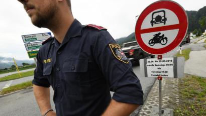 Bild: Angelika Warmuth/dpa
Ein österreichischer Polizist steht vor einem Schild, das auf die Sperrung für den Verkehr mit Fahrziel Italien hinweist.