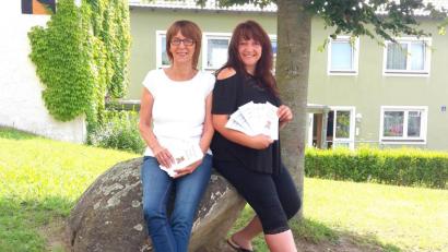 Bild: fjo
Bürgermeisterin Margit Kirzinger (links) präsentiert die frisch gedruckten Flyer des neuen Ferienprogramms von Jugendbeauftragter Ramona Stefinger.