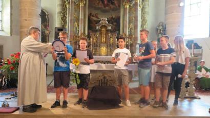 Bild: jzk
Gute Wünsche für eine erholsame Ferienzeit bringen einige Mädchen und Jungs für ihre Mitschüler mit symbolischen Gaben zum Ausdruck.