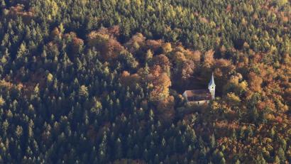 Bild: Franz X. Bogner
Fangen wir zur Ankündigung unserer Luftbilder-Serie mal etwas einfacher an: Es ist natürlich die Johanniskirche auf dem gleichnamigen Hausberg von Freudenberg, die hier im Herbstwald zu sehen ist.