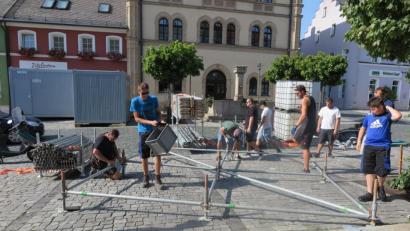 Bild: jzk
Die größte Hitze ist vorbei, als am Freitagabend Mitglieder des SVSW Kemnath und TSV Kastl auf dem Stadtplatz mit dem Aufbau der Bühne beginnen.