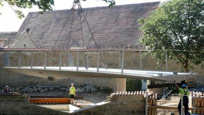 Bild: Wolfgang Steinbacher
Der erste Teil des neuen Pionierstegs ist schon eingebaut, jetzt schwebt der zweite ein. Für den großen Kran im Stadtgraben war es ganz schön eng, vom Kranführer Präzisionsarbeit gefragt.