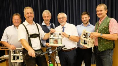 Bild: mab
Ein neues "Gemeindefahrzeug" in Form eines umweltfreundlichen E-Bikes und flüssige Grüße von der "Weltgrößten Holzkugel" hatte die Schwarzenfelder Delegation mitgebracht. Auf dem Bild die Bürgermeister mit ihren Vertretern bei der Überreichung.