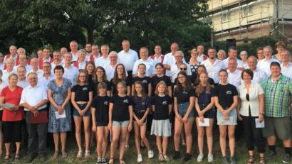 Bild: cro
In sommerlicher Atmosphäre sangen Ensembles und Zuhörer gemeinsam "Kein schöner Land in dieser Zeit". MGV-Vorsitzender Stefan Meiler (links) führt durch das Programm, Chorleiter Herbert Kraus (vorne, rechts) hat das Programm gestaltet.