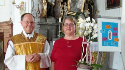 Bild: hl
Pfarrer Heribert Stretz überreicht zum Abschied eine Orchidee an Madlen Heser.