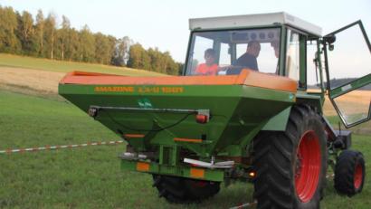 Bild: frd
Mit seinem am Traktor angebrachten Streuer führte Johannes Hösl die effiziente Mineraldüngerausbringung vor. Das linke Trassierband stellte den Feldrand dar. Über diese Grenze hinaus sollte nicht gedüngt werden.
