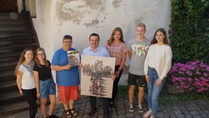 Bild: kaz
Die Oberministrantinnen Jennifer Zapf und Alina Hierlein, Gemeindereferent Jochen Gößl sowie die Gruppenleiter Anna Schicker, Vinzenz Schöcklmann und Maria Nickl (von rechts) verabschieden sich mit einem Fotobuch und einer Leinwand von Pfarrer Konrad Amschl.