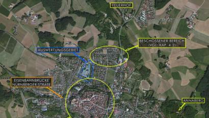 Bild:  Luftbilddatenbank Dr. Carls GmbH/©Microsoft Corporation
Im hinterlegten aktuellen Luftbild aus dem von der Stadt angeforderten Gutachten werden die von amerikanischer Artillerie bei der Einnahme Sulzbach-Rosenbergs am 21. April 1945 beschossenen Bereiche sowie die gesprengte Eisenbahnbrücke in der Nürnberger Straße schematisch dargestellt. Das Auswertungsgebiet, in dem die Stadtgärtnerei liegt, ist blau umrandet.