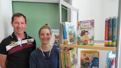 Bild: exb
Das Sommerferien-Leseclub-Team, Patrizia Spörl und Johannes Klug, zeigt das Foto vor den 100 extra für die Aktion angeschafften Büchern.
