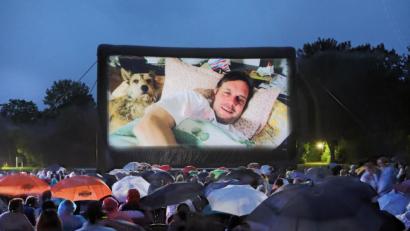 Bild: Gerhard Götz
Die Open-Air-Kinobesucher sind mit Regenschirmen, Capes und wasserdichten Jacken für den heftigen Regenguss gerüstet und lassen sich ihren „Leberkäsjunkie“ nicht vermiesen.