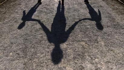 Bild: Peter Kneffel/dpa
Der Schatten einer Frau mit ihren beiden Kindern auf einen Gehweg. Alleinerziehende in Bayern sollen künftig steuerlich entlastet werden